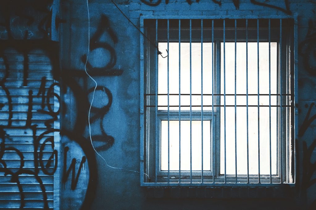decorative image: graffiti and a barred window.