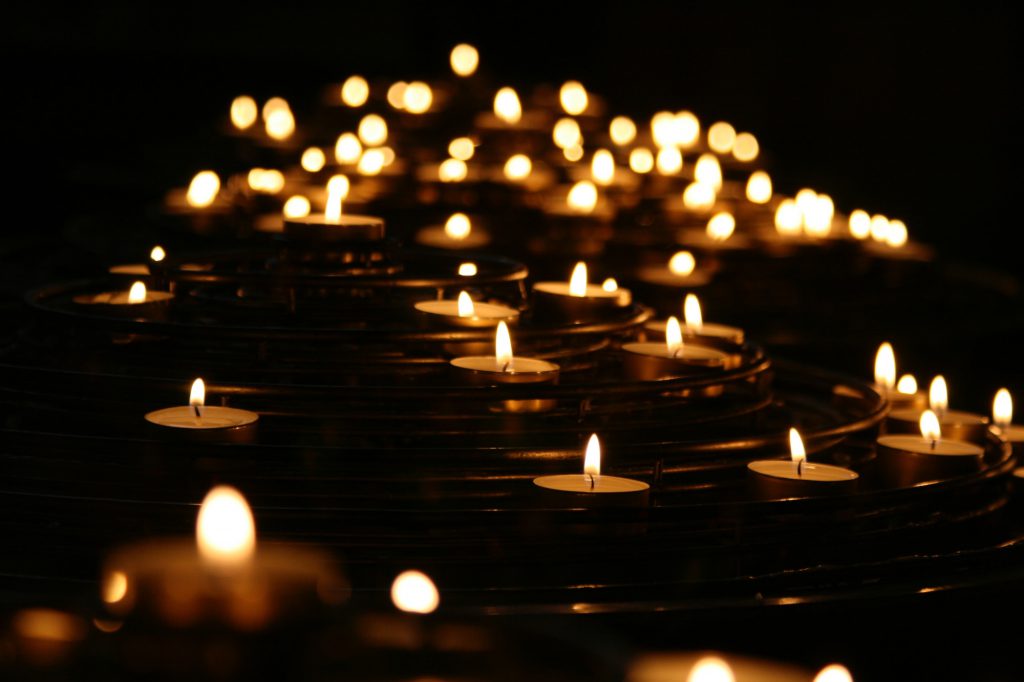 decorative image: lit candles on dark water.