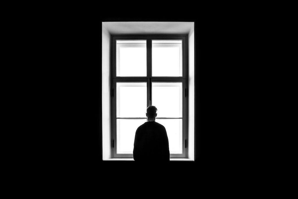 decorative image: figure looking out window, black and white